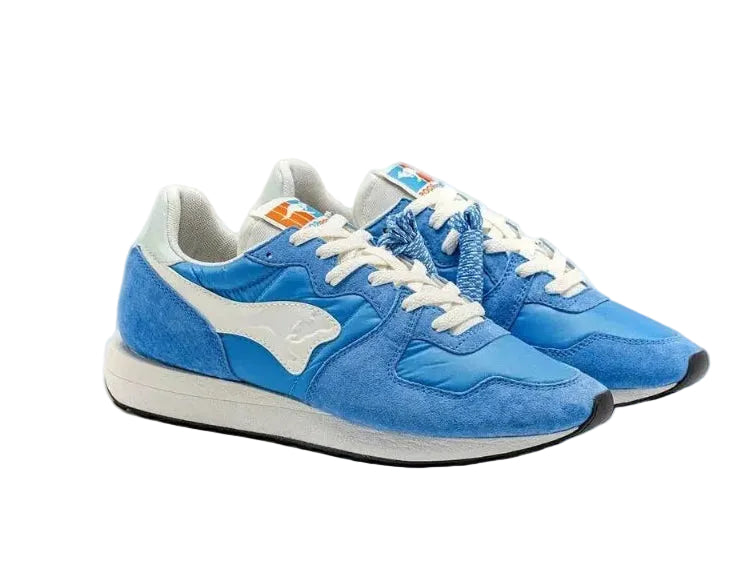 Blauwe sneakers zijkant met witte panelen, veters en lichtgrijze zool